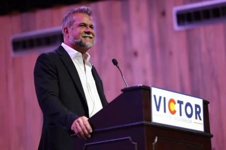 Victor Marx speaking at a podium with "Victor" title,